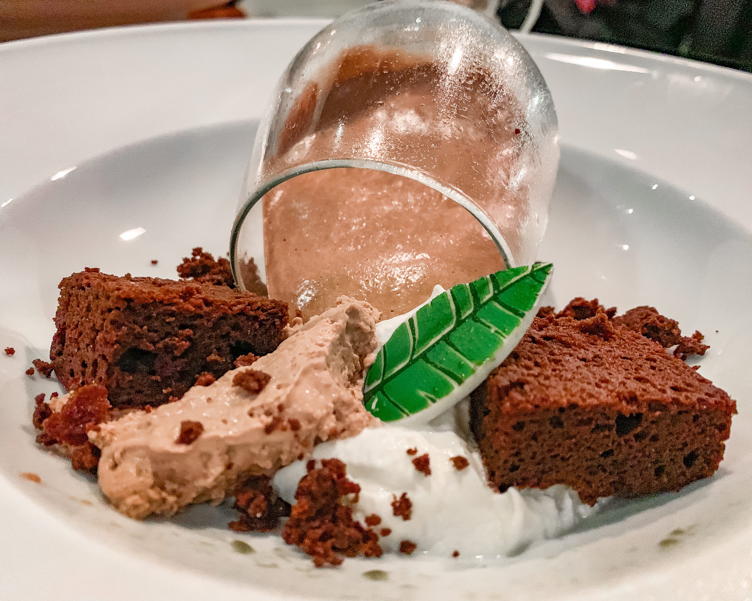 Cigar-Smoked chocolate Mousse Cake with dark chocolate basil semifreddo served in a wine glass.