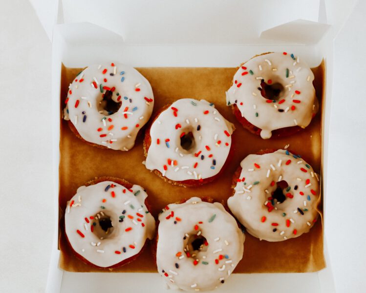 box of birthday cake donuts with vanilla frosting and sprinkles