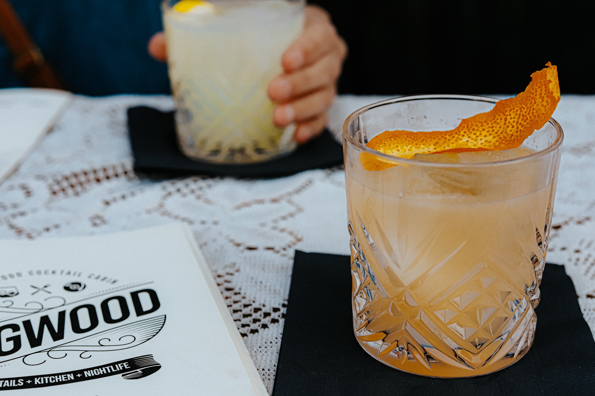 Fancy cocktail glass holds an orange cocktail garnished with an orange peel at Dogwood cocktail bar in bend oregon