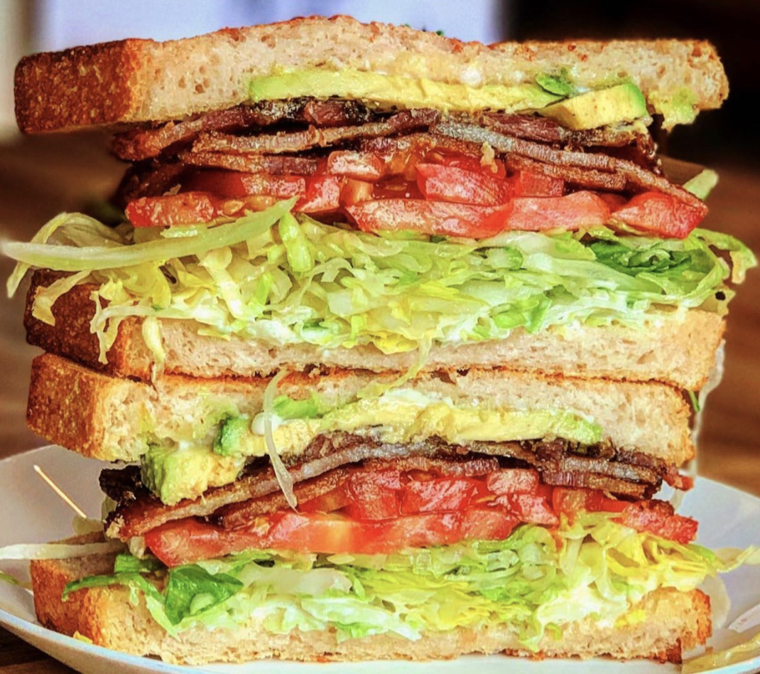 BLT sandwiches are stacked on top of each other showing the inside of the sandwich