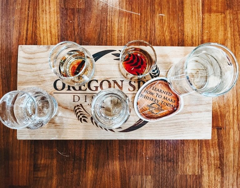 Wooden board holding a flight of whiskey from Oregon Spirit Distillers