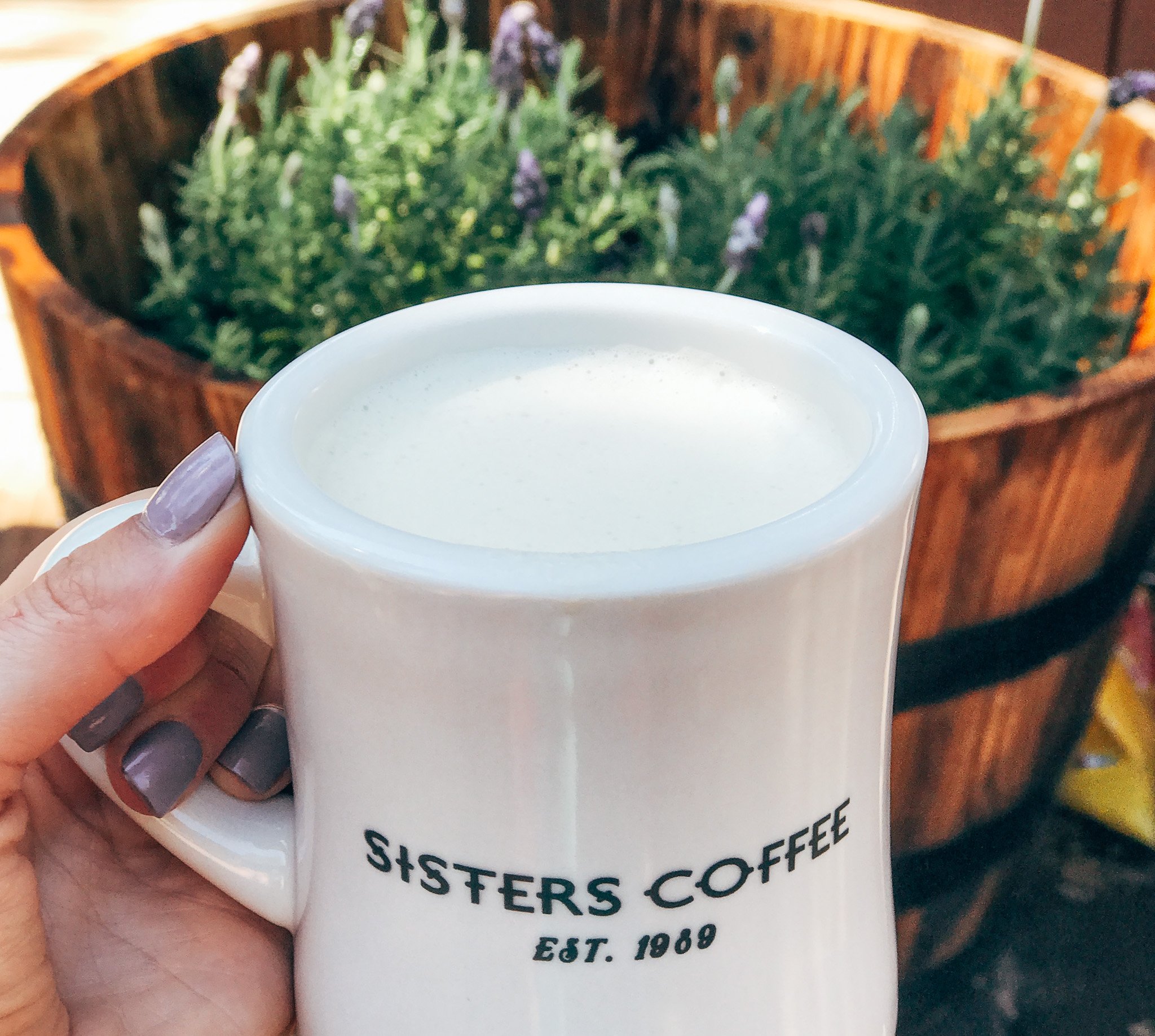 Cup of coffee reads Sisters Coffee established 1989