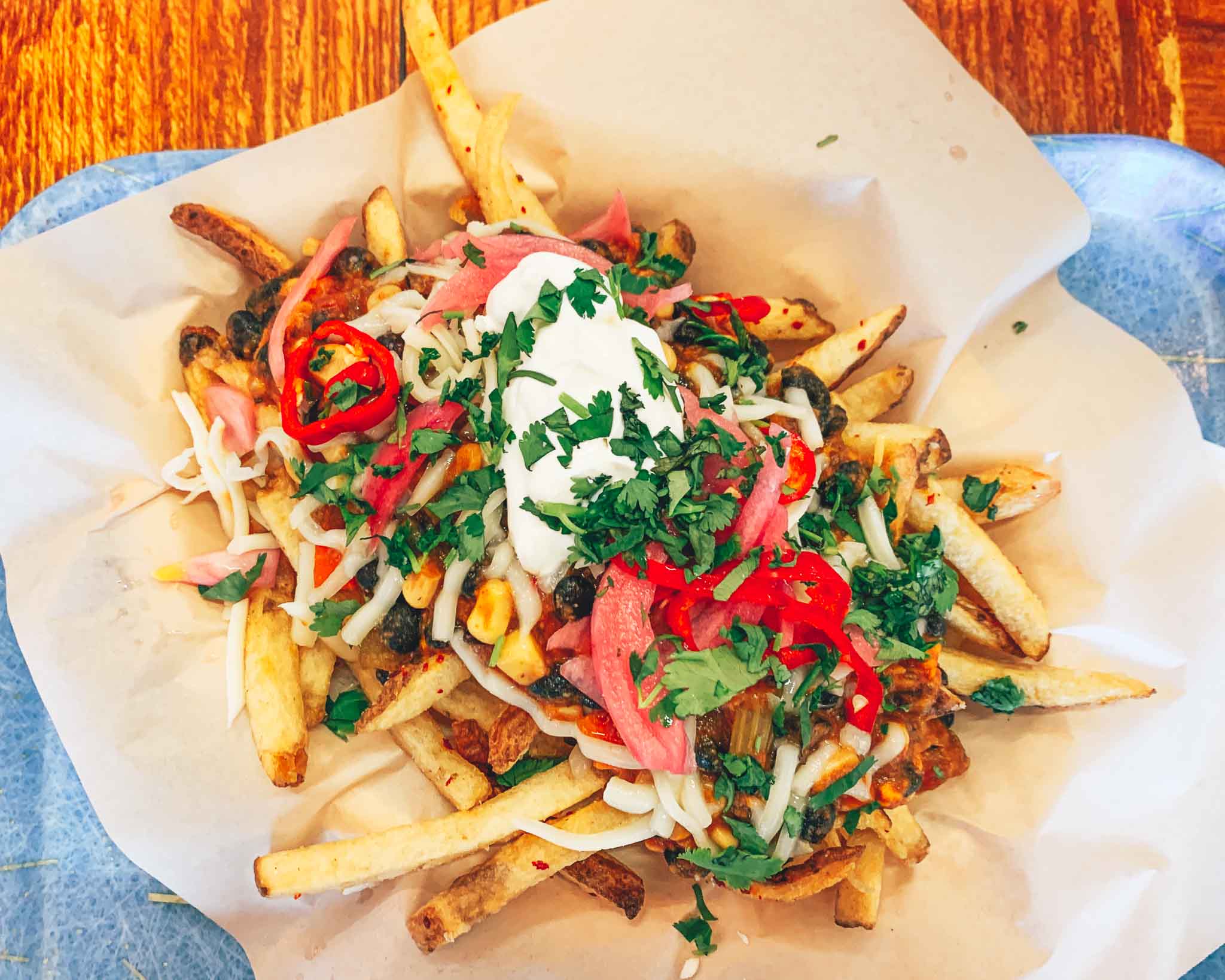 french fries topped with sour cream, onions, chives, and chili