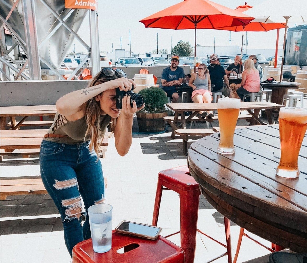 Nancy Patterson of Eat Drink Bend takes a picture of beer on a table outside in Bend, Oregon.