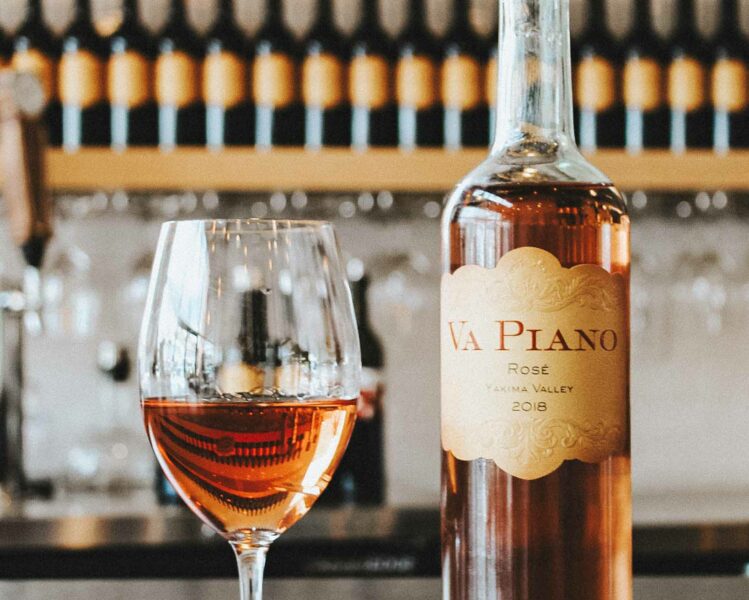glass of rosé sits next to a bottle of va piano vineyards wine