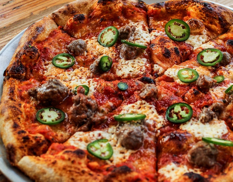 Pizza is covered with jalapenos and honey