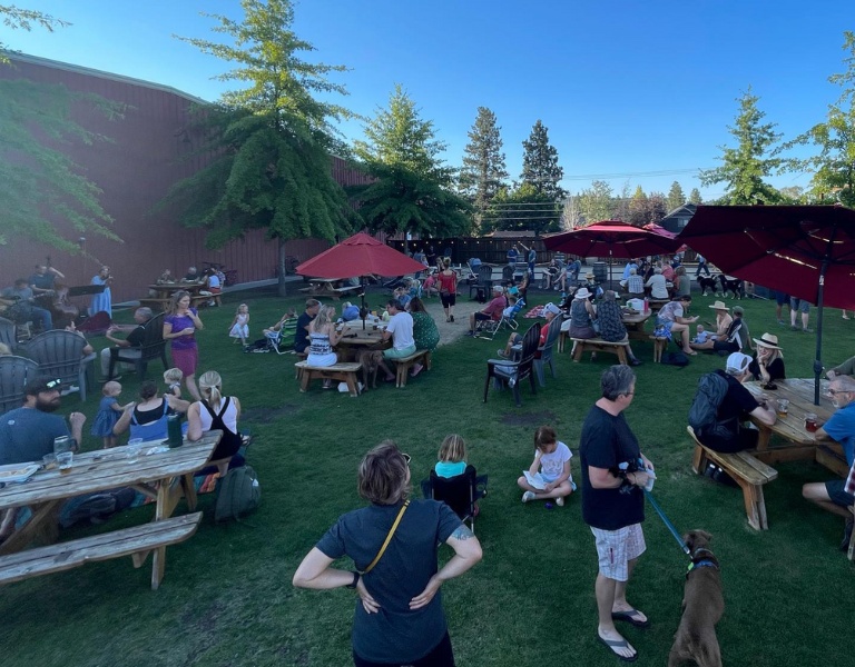 birds eye view of the lawn at good life brewing while guests play cornhole