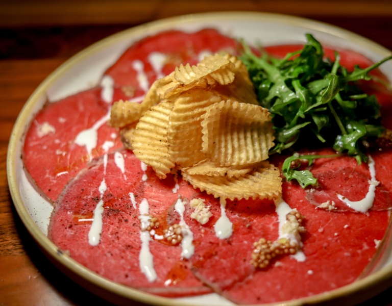 thinly sliced carpaccio topped with potato chips
