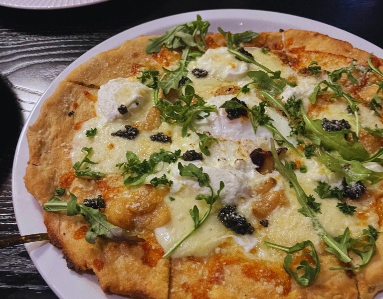 pizza with egg, caviar, and arugula 